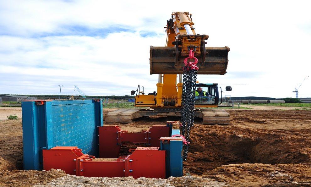 A Rolling Strut Trench Box being installed into the ground with vertically adjustable struts